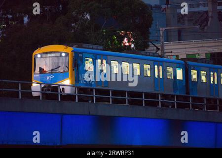 Öffentliche Verkehrsmittel Melbourne zeigt einen elektrischen Personenzug, der auf Bahngleisen in einem städtischen Stadtgebiet fährt. Stockfoto