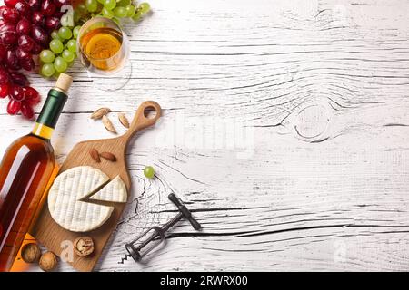 Weiße Flasche Wein, Trauben, Käse und Weinglas auf weißem Holzbrett. Ansicht von oben mit der Kopie. Stockfoto