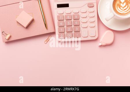 Rosafarbener Bürotisch, Notizblock, Tastatur, Blumen, Kaffee, Hut, Notizbuch, Schreibwaren auf rosafarbenem Hintergrund. Business Minimal-Konzept für Frauen. Flach liegend, oben Stockfoto