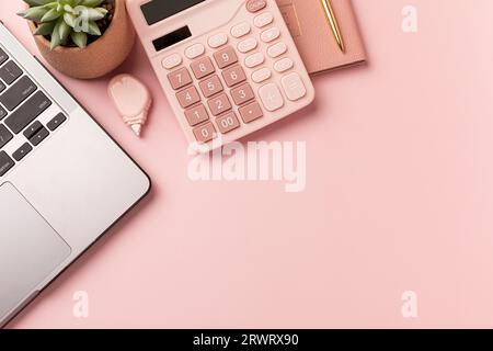 Arbeiten mit Laptop-Computer, heißer Kaffee und Kakteen Kopierraum auf rosafarbenem Tischhintergrund. Draufsicht, flache Lage, Stil Minmal Arbeitsplatz, Geschäftskonzept. Hoch Stockfoto