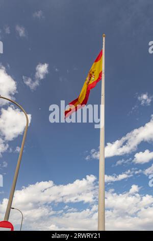 Die Flagge Spaniens fliegt im Wind, vor dem Hintergrund eines atemberaubenden blauen Himmels vor der Gibraltar Passport Control Station, Gibraltar Stockfoto