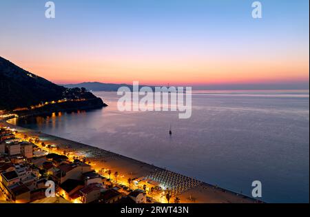 Die Stadt Scilla Calabria Italien. Erhöhter Blick auf den Marina Grande Strand bei Sonnenuntergang und die Straße von Messina Stockfoto