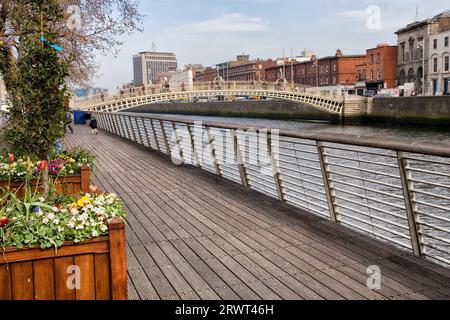 Boardwalk entlang des Flusses Liffey und der Ha'Penny Bridge in der Stadt Dublin, Irland Stockfoto