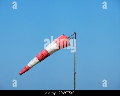 Rot-weißer Wirbelwind, vom Wind getroffen, blauer Himmel im Hintergrund Stockfoto