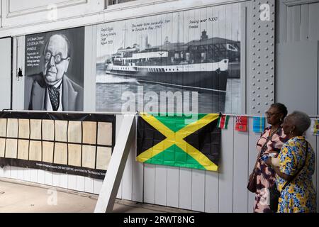 Ausstellung zum Windrush Day am Fährhafen Tilbury Docks, mit Jamaika-Flagge und Bildern des Architekten Sir Edwin Cooper und des 1933 erschienenen Schiffes Royal Eagle Stockfoto