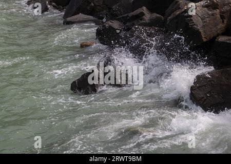 Luftaufnahme von Wellen, die auf großen Felsen eines Wellenbrechers plätschern Stockfoto