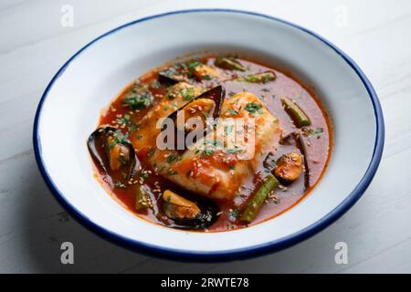 Seehecht mit Tomatensauce und Muscheln. Traditionelles Rezept aus Nordspanien. Stockfoto