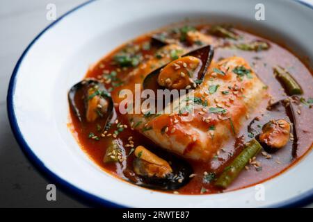 Seehecht mit Tomatensauce und Muscheln. Traditionelles Rezept aus Nordspanien. Stockfoto