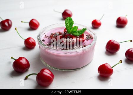 Kirschpanna Cotta in einem Glas mit frischem Obst und geriebener Schokolade. Stockfoto