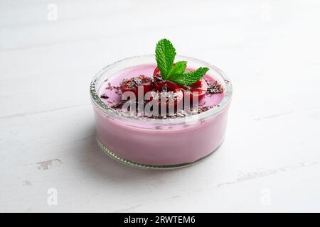 Kirschpanna Cotta in einem Glas mit frischem Obst und geriebener Schokolade. Stockfoto
