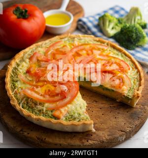 Quiche im französischen Stil mit Brokkoli, Lachs und Tomatenscheiben. Stockfoto