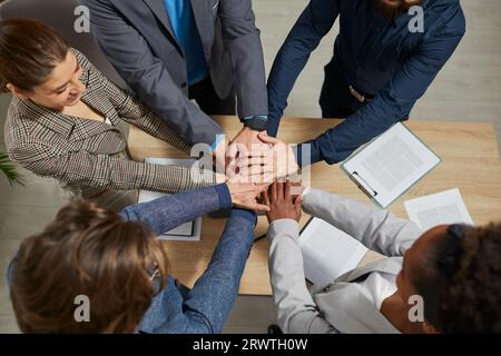 Die Gruppe der Geschäftsleute legt ihre Hände übereinander Stockfoto
