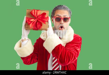 Porträt eines lustig überraschten jungen Mannes in einem Weihnachtsmannkostüm. Stockfoto