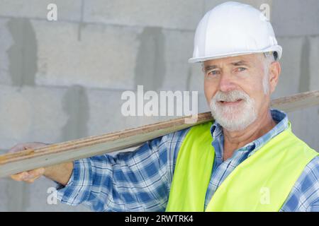 Ein Zimmermann mit Holzbohlen Stockfoto