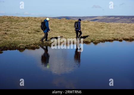 Zwei Männer (Wanderer) reflektiert in Small Tarn auf „Proctor High Mark“ in der Nähe von Malham, Yorkshire Dales National Park, England, Großbritannien Stockfoto