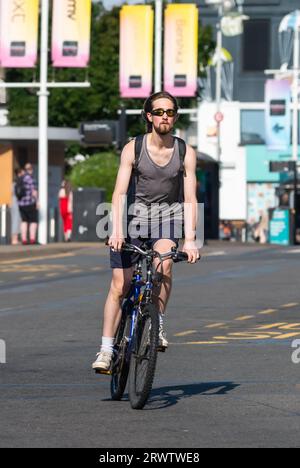 Junger Mann, der ohne Helm auf dem Fahrrad fährt. Männlicher Radfahrer, der auf einer Straße in Großbritannien fährt, ohne einen Fahrradhelm zu tragen. Stockfoto