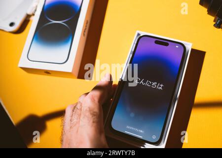 Paris, Frankreich - 17. September 2022: Anzeige des neuen Apple iPhone 15 Pro Max mit asiatischen Charakteren beim Auspacken und Einrichten Stockfoto