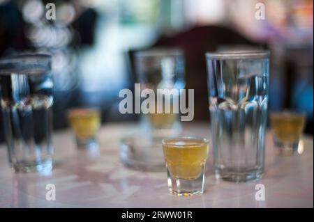 Wassergläser mit Shot-Gläsern auf einem Tisch an der Bar Stockfoto