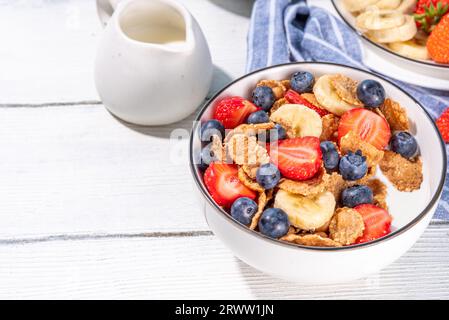 Gesunde Vitamindiät Sommerfrühstück. Cornflakes mit mehreren Körnern, Joghurt oder Milch und Erdbeeren, Blaubeeren, auf dem Küchentisch Kopierraum Stockfoto