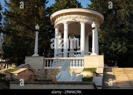 Rotunde, ein wunderschönes weißes architektonisches Gebäude mit Säulen im Park. Ein gut ausgestattetes Erholungsgebiet im Park Stockfoto