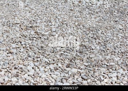 Kies aus großen Fraktionen, Steinbrüche, Bausteine aus Zuschlagsteinen. Nahaufnahmen von zerquetschten Steinen liegen auf dem Boden. Breakstone. Granitkies Stockfoto