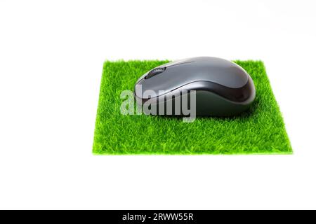 Nahaufnahme einer Computermaus, die auf einem Mousepad aus synthetischem Gras platziert wird. Stockfoto