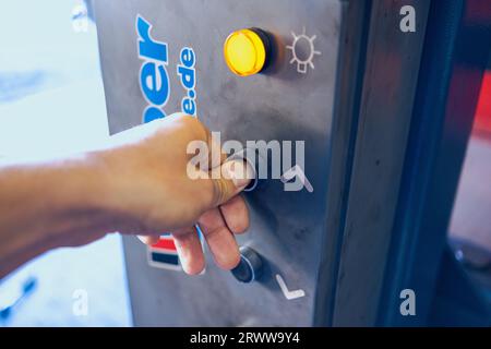 Der Finger drückt auf den Knopf des Fahrzeughubs. Heben Sie die Bedienkonsole an. Die gelbe Anzeigeleuchte leuchtet. Stockfoto