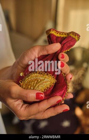 Frauen halten rote esoterische Tasche mit goldenem orientalischem Muster und nehmen Tarotkarten aus dem okkulten Beutel Stockfoto