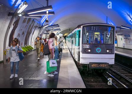 Passagiere warten auf dem Bahnsteig, während ein Pariser U-Bahn-Zug mit der Linie 4 in Paris, Frankreich, zur Haltestelle Gambetta fährt. Stockfoto