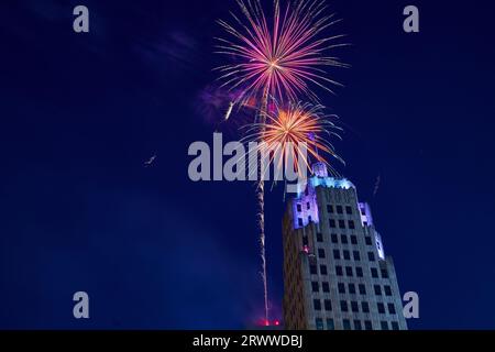Schließen Sie am 4. Juli den Lincoln Tower mit blauen und violetten Lichtern und einem orangen und roten Feuerwerk Stockfoto