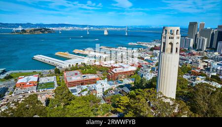 Aus der Luft neben dem Coit Tower auf dem Telegraph Hill mit Blick auf die Stadt mit Booten und Oakland Bay Bridge Stockfoto