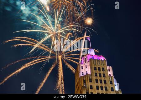 Goldenes Feuerwerk hinter dem Lincoln Tower in der Innenstadt von Fort Wayne am 4. Juli mit violetten Lichtern Stockfoto
