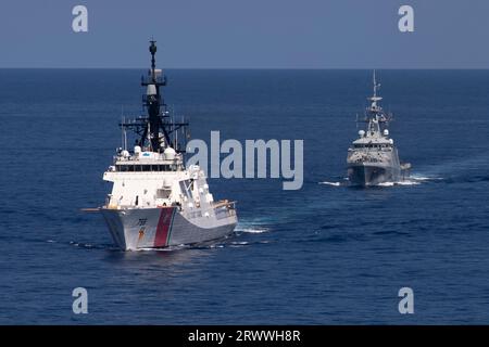 Südchinesisches Meer, Internationale Gewässer. 17. September 2023. Der US-Küstenwache Legend-Class Cutter USCGC Munro, links, führt koordinierte Schiffsmanöver mit dem Royal Navy River-Class Offshore Patrouillenschiff HMS Spey, 17. September 2023, im Südchinesischen Meer durch. Quelle: CPO Brett Cote/US Navy Photo/Alamy Live News Stockfoto