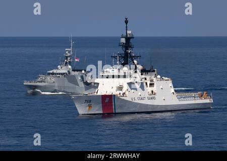 Südchinesisches Meer, Internationale Gewässer. 17. September 2023. Der US-Küstenwache Legend-Class Cutter USCGC Munro, rechts, führt koordinierte Schiffsmanöver mit dem Royal Navy River-Class Offshore Patrouillenschiff HMS Spey, 17. September 2023, im Südchinesischen Meer durch. Quelle: CPO Brett Cote/US Navy Photo/Alamy Live News Stockfoto