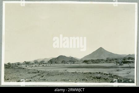 Eine von sieben Bildern mit dem Titel „North Kavirondo Agricultural Show“. Mumias. Januar: 1931.“ Eine Gruppe afrikanischer Menschen, die in einer Mischung aus westlicher Kleidung und traditionellen Kostümen gekleidet sind, wartet auf die Präsentation beim Gouverneur. Stockfoto