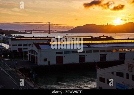 Sonnenuntergang über den Bergen hinter der Golden Gate Bridge mit Blick von den Lagerhäusern auf dem Pier Stockfoto