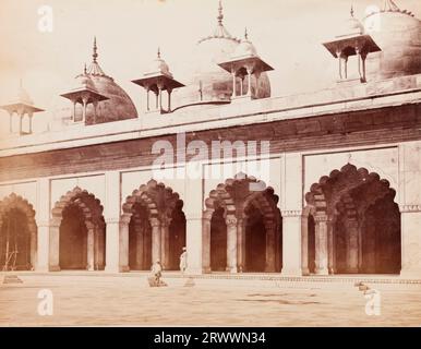 Außenansicht der weißen Moti Masjid (Perlenmoschee), die sich im Agra Fort Komplex befindet. Über dem Bogengang befinden sich drei große Kuppeln. Ein Indianer beugt sich an einer der Säulen und ein anderer Indianer geht die Stufen zum Innenhof hinunter. Auf negativ eingeschrieben: Frith's Series. 3077 Das Motee Musjid; Agra. Die Bildunterschrift lautet: Exterieur of the Motee (oder Pearl) Musjid, Agra. Stockfoto