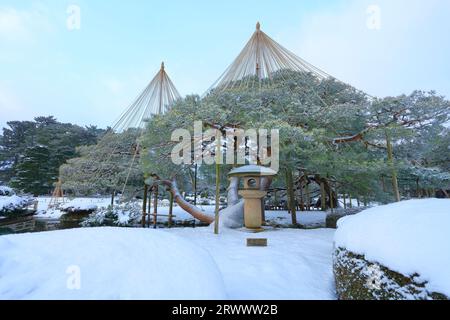 Kanazawa Kenrokuen Garten im Winter, Schnee hängt von Kiefern vor Mondlaternen Stockfoto