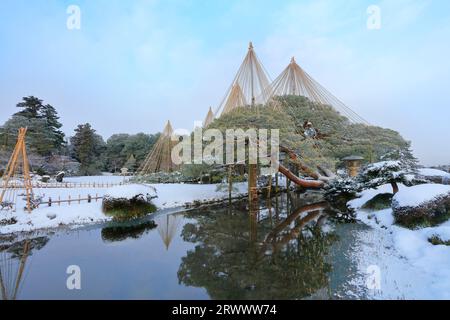 Schneehängige Kiefern und Tsukimi-Laternen im Kanazawa Kenrokuen Garden im Winter Stockfoto