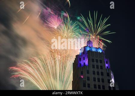 Sie zoomten im Blick auf das schillernde Feuerwerk hinter dem Lincoln Tower mit violetten und blauen Lichtern in Fort Wayne Stockfoto
