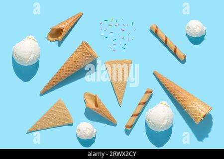Von oben sehen Sie Eisbecher, Streusel, Zigarren und Fans auf Blau mit hartem Schatten, Sommerkonzept. Stockfoto