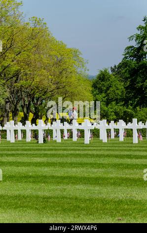 Ein US-Soldat trägt seinen Kind durch die Gedenkstätte Kreuze im Cambridge Friedhof und Denkmal. Grab Grabsteine und Flags Stockfoto