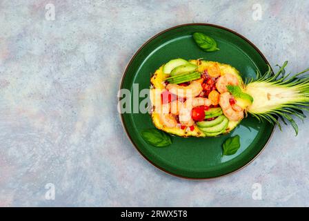 Farbenfroher Salat in Ananas mit Reis, Gemüse und Garnelen auf dem Tisch Stockfoto