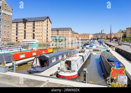 Gloucester dockt Schmalboote im Victoria Basin an, mit viktorianischen Lagerhäusern, die in Wohnungen umgebaut wurden Gloucester Gloucestershire England GB Europa Stockfoto