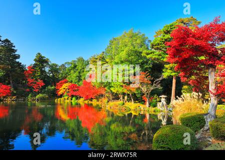 Herbstlaub auf der Koji-Laterne und dem Kasumigaike-Teich im Kanazawa Kenrokuen-Garten im Herbst. Stockfoto