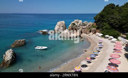 Albanische Riviera - wunderschöner Rocky Beach mit Sonnenschirmen - Luftblick Stockfoto