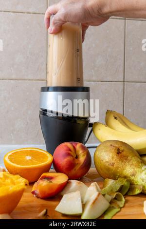 Zubereitung eines Smoothies mit frischen Früchten in einem Mixer. Gesunder Lebensstil, Gesundheitskost-Konzept. Stockfoto