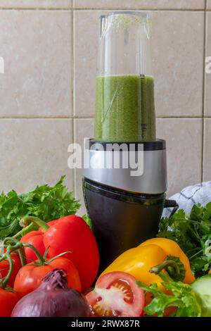 Zubereitung von Gemüse-Smoothie mit frischem Gemüse in einem Mixer. Gesundheitskost und Lebenskonzept. Stockfoto