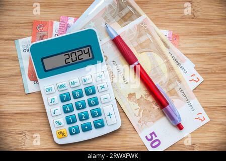 2024 Zahlen auf einem Rechner und Euro-Banknoten, Neujahrsfinanzierung, Geld, Inflation und Haushaltsdarstellung Stockfoto