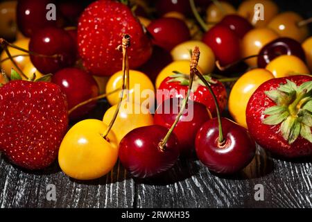 Rot-gelbe Kirsch-Erdbeere auf Holzhintergrund Stockfoto